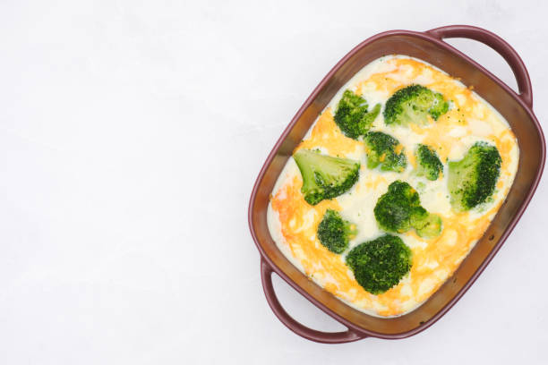 Quiche broccoli. Egg Frittata ready for baked. Baked egg frittata with spinach, cheese, broccoli, milk. Served on grey background.