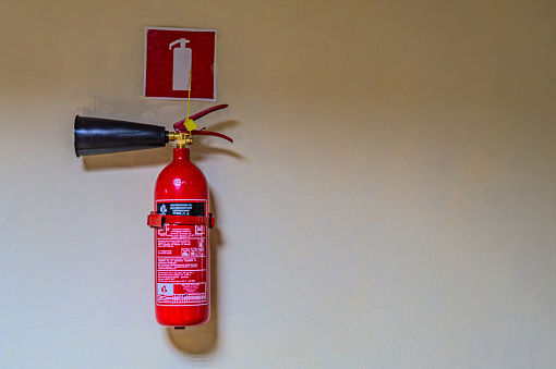 fire extinguishers available in fire emergencies. Fire extinguisher on the gray wall Kharkiv Ukraine 05-05-2023