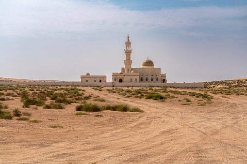 The minaret and dome of an isolated mosque in the Wahiba desert of Oman.