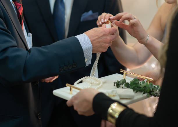 Close up groom wears the ring bride.