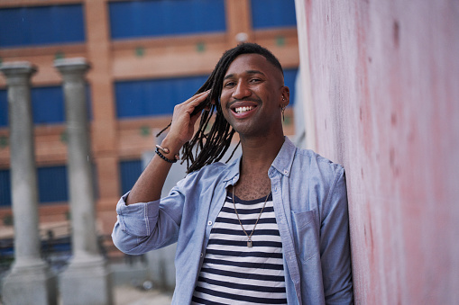 portrait of a young African-American man with a beret and braids in the city