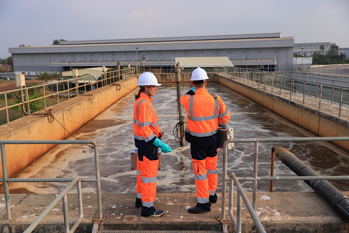 male and female environmentalist engineers work on concrete for wastewater treatment.Recycling and Ecology concept. Waste processing and water treatment plant