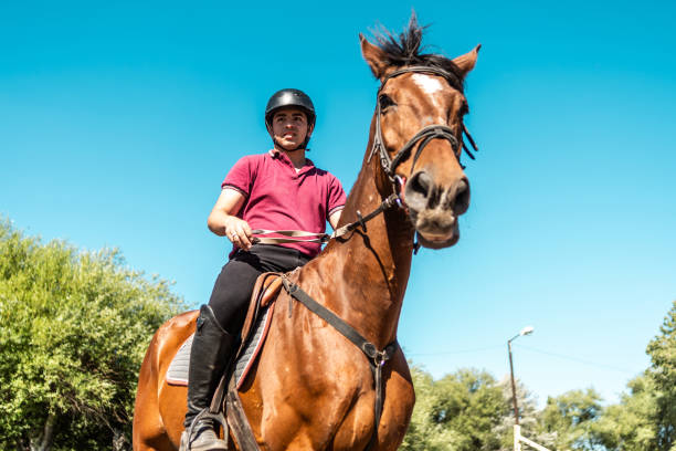 istock Teenager boy horseback riding on a stable 2073933712