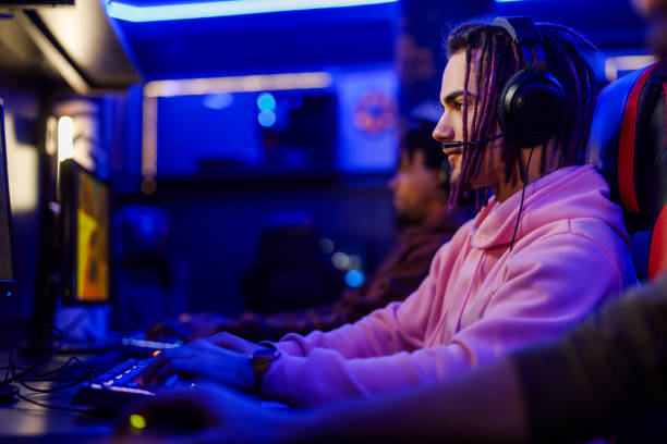 istock Concentrated young male with dreadlock playing video games in a an internet cafe 2073954686