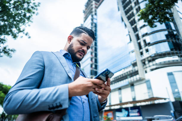istock Young businessman using mobile phone in the city 2073957363