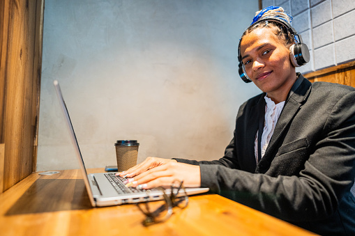 Portrait of a young woman working using laptop at office