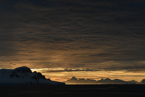 GLowing sunshine behnd antarctic mountains