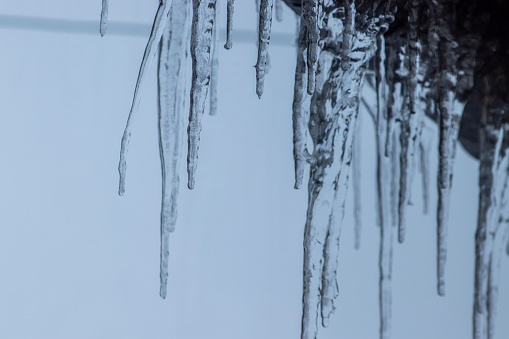 icicles on house roof in cold winter