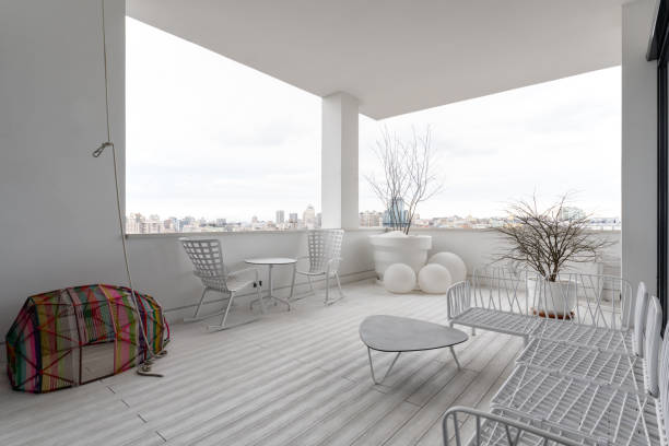 istock White porch with wooden table and chairs, overlooking a window with a view 2074026168