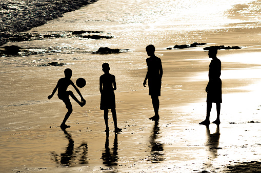 Salvador, Bahia, Brazil - February 14, 2019: Young people are seen having fun and playing beach soccer in the late afternoon in the city of Salvador, Bahia.