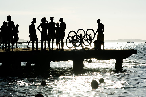 Salvador, Bahia, Brazil - March 09, 2019: Dozens of young people, in silhouette, are seen on top of the Crush bridge having fun. City of Salvador, Bahia.