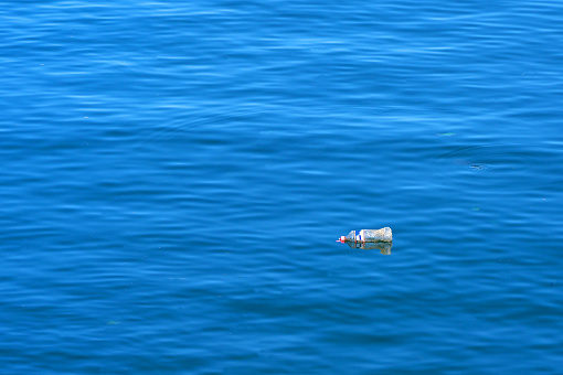 Plastic water bottle floating at sea, Pollution concept.