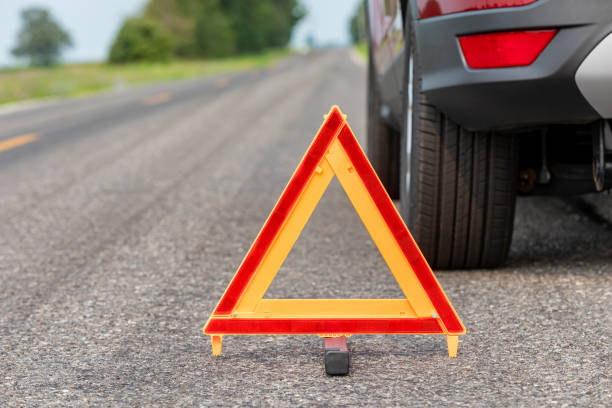 Car breakdown on side of road with warning triangle. Emergency roadside assistance, auto insurance, and vehicle repair concept
