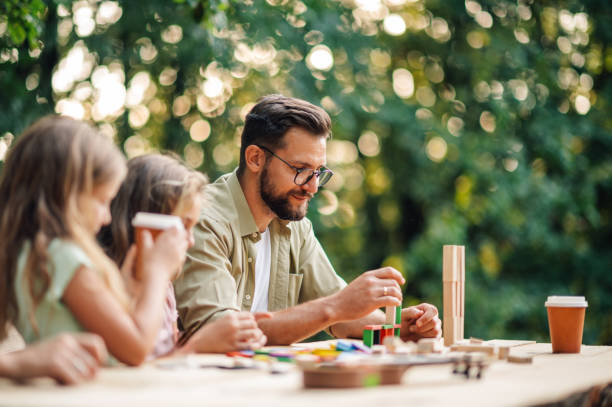 istock A father playing fun building a tower game in nature with children. 2074088225