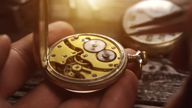 Watchmaker holds the vintage pocket watch. Mechanical watch repair