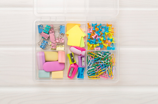 Colorful stationery in organizer on wooden background, top view