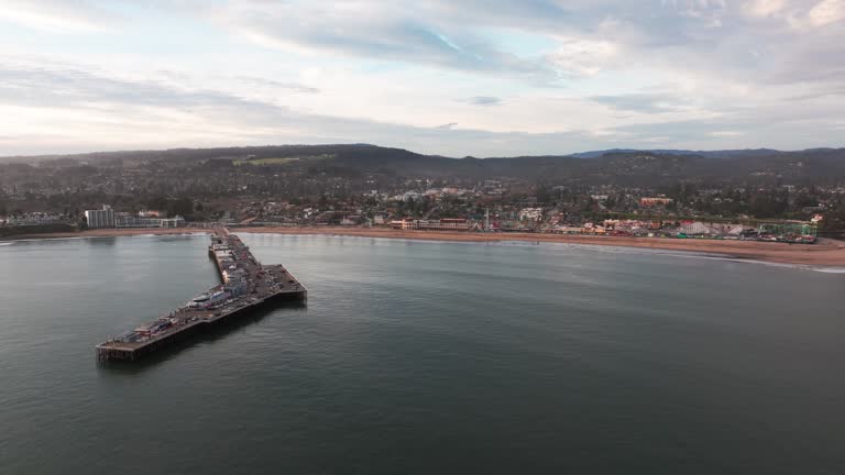 Aerial drone shot flying in towards the santa cruz beach during sunset