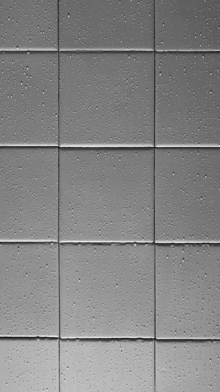 The texture of light gray square glossy ceramic tiles with water drops. Bottom soft lighting.