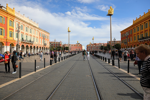 Nice, France - April 24, 2023: The tram line crosses Place Massena, the main square of the city, with buildings on both sides of the square. There is usually a lot of pedestrian traffic in this square