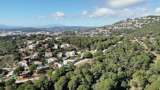 Aerial panoramic view, houses on the mountains with green pine trees in the mediterranean forest, 4K