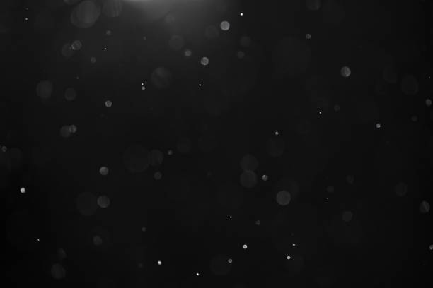 abstract real dust floating over black background for overlay stock photo