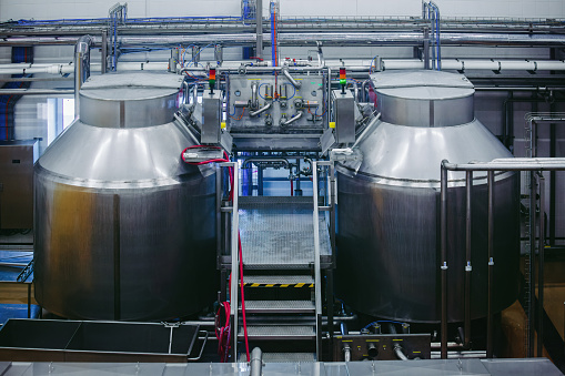Modern cheese factory, stainless steel milk processing tanks.