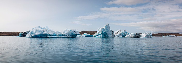 Icelandic glacial scenery, magnificent ice form, iceberg floating in the calm blue water. Unique nature sights and trip concepts.