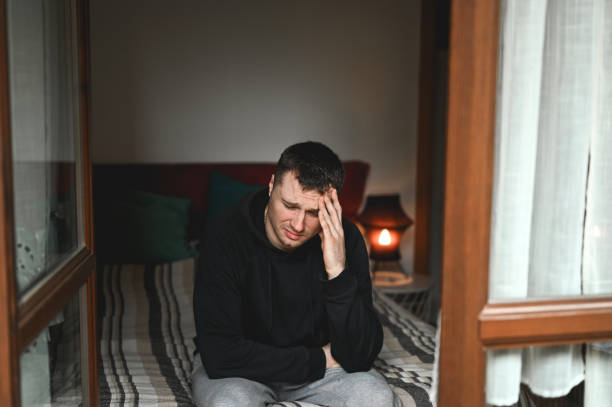 istock men with depression sitting on the bed 2074387256