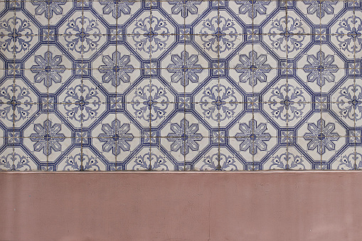 Blue traditional Portuguese ceramic tiles pattern, azulejos. Beautiful shabby dirty pink facade, wall banner. Old Lisbon building decoration Portugal, decorative background with geometric stars ornaments.