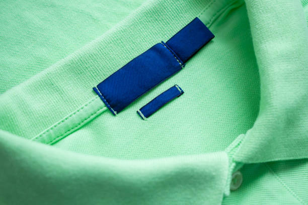 istock Blank blue laundry care clothes label on green shirt fabric texture background 2074427580
