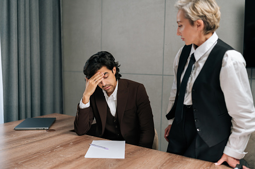 Aggressive female boss reprimands incompetent male employee for bad work result, decreasing financial stats in report, scolds for inefficiency. Executive manager dissatisfied with declining project