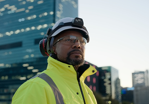 Man, construction worker and thinking at cityscape building for development or civil engineering, planning or architect. Male person, hardhat and downtown New York view for contractor, service or job
