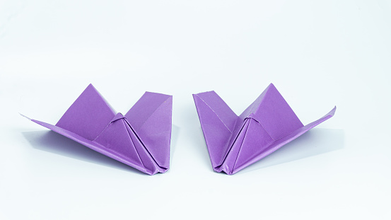 Purple paper airplane isolated on white background