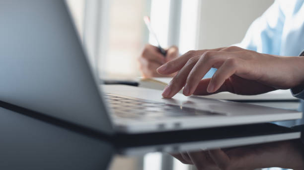 istock Business woman working on laptop computer and writing note on notebook. Female student searching the information on laptop computer during online studying, e-learning,  business planning 2074551096