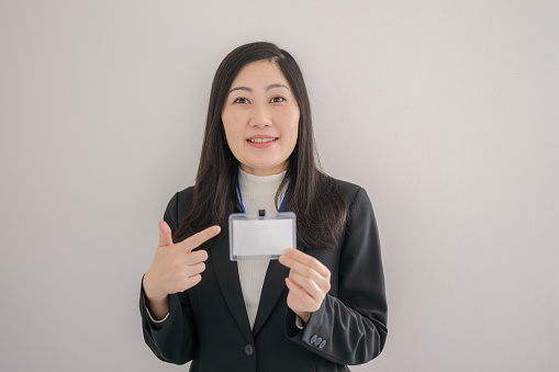 showing xwoman presenting blank gift card sign. Happy smiling Asian xwoman in red winter sweater isolated on white background.