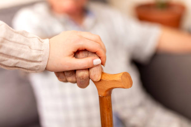 istock Home caregiver showing support for elderly patient 2074581439