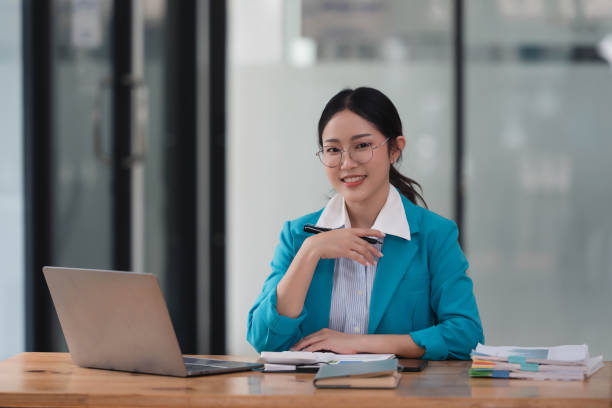 istock Female financial advisor or accountant  reviews her documents and using laptop. 2074695272