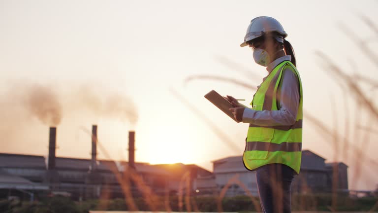 Inspection engineers working with Digital tablet of gas plant and refinery oil factory industry at Dusk