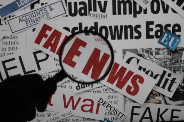 istock newspaper under a magnifying glass exposing Fake news.with selective focus. 2074750508