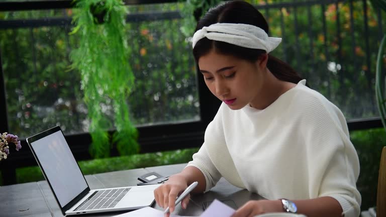 Businesswoman hands type on laptop writing on notebook meeting at office desk. Asian Woman Hands writing planning on office paper use calendar from laptop. Female hand holding pen work Business Plan