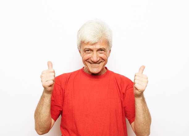 Emotion, lifestyle and old people concept: Portrait of energetic positive old man show okay sign stock photo