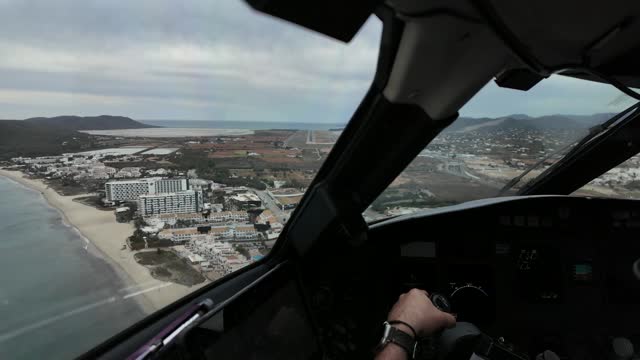 Pilot FPV POV arriving to Ibiza airport, Spain, overflying the coastline. Immersive Captain perspective. 4K. Clouded sky with moderate wind and turbulence.