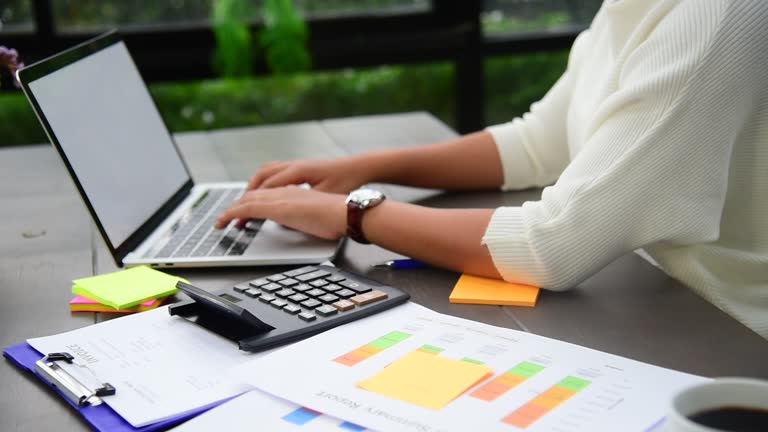 Businesswoman hands type on laptop writing on notebook meeting at office desk. Asian Woman Hands writing planning on office paper use calendar from laptop. Female hand holding pen work Business Plan