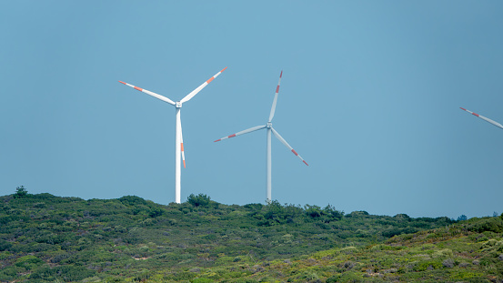 Wind turbines placed on mountains on sunny morning