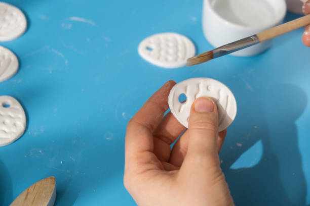 istock Creator is using white air dry clay for making decor to EASTER holiday. Creating hobby recreation activity that involves fingers. DIY crafting 2074814673