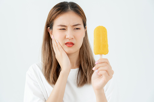 Asian woman feel sensitive teeth after eating ice cream, female suffer tooth, decay problems, dental care, tooth extraction, decay problem, bad breath, Gingival Recession, Oral Hygiene instruction