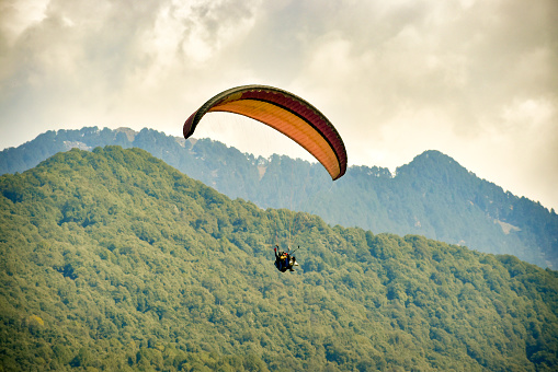 Young man paragliding with an instructor over beautiful mountain of Himachal Pradesh, Bir- Billing India.