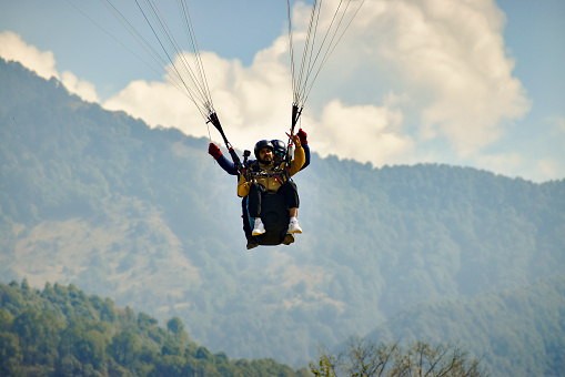 Gliding with a parachute on the background of bright sunset.