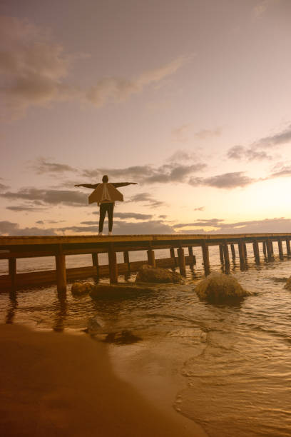 Young pilot chasing his dreams on the pier above the sea