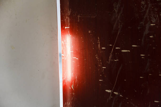 A shiny silver surface with a reflective quality. The surface appears to be a part of a machine or a structure, possibly an elevator or a refrigerator